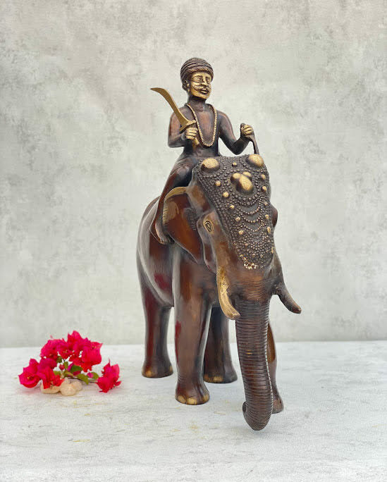 athepoo- a brass elephant and soldier statue with some flowers