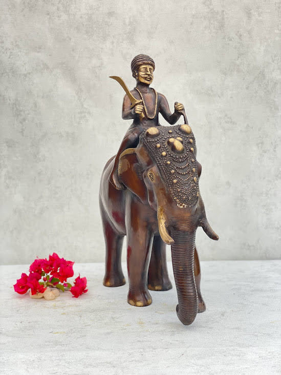 athepoo- a brass elephant and soldier statue with some flowers