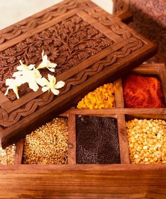 athepoo- A wooden spice box having some spices inside the box